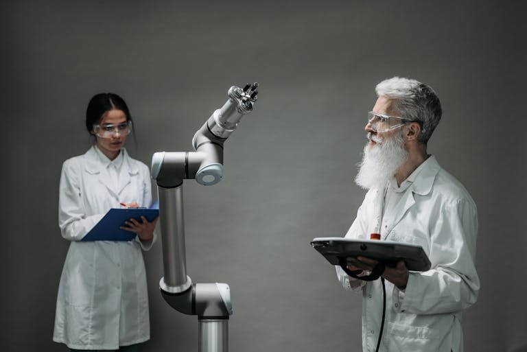 Two scientists working with a robotic arm in a lab setting, focusing on innovation and technology.